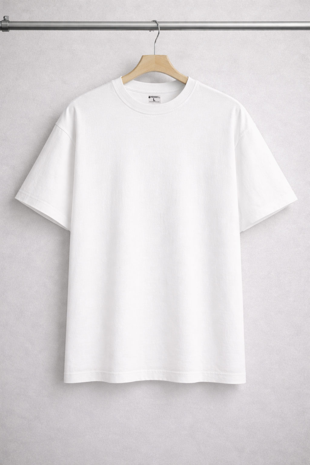 White t-shirt on a hanger against a gray background